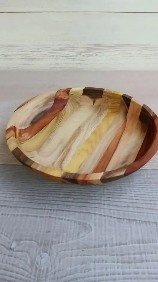 Handmade round wooden serving bowl with striped grain.