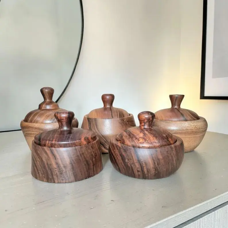 Handmade walnut and pear wood jars with fitted lids.